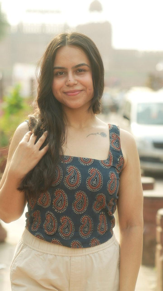 Woman wearing a patterned top with a blurred outdoor background